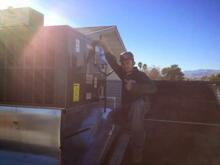 HVAC technician performing Boiler Repair on a rooftop unit in Morgantown